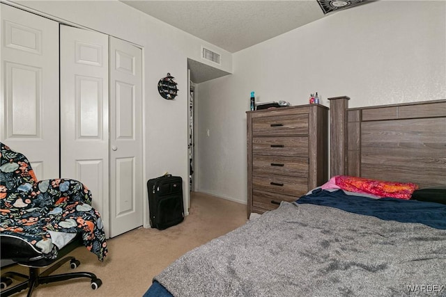 bedroom featuring a closet, light carpet, and a textured ceiling