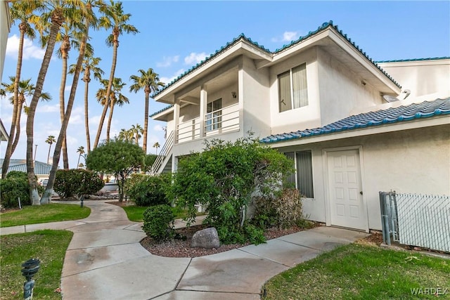 exterior space featuring a front yard, fence, and stucco siding