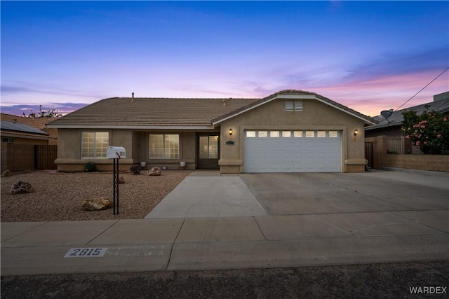 single story home with fence, stucco siding, concrete driveway, an attached garage, and a tile roof