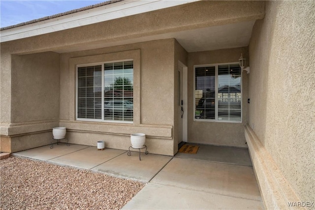 view of exterior entry with stucco siding