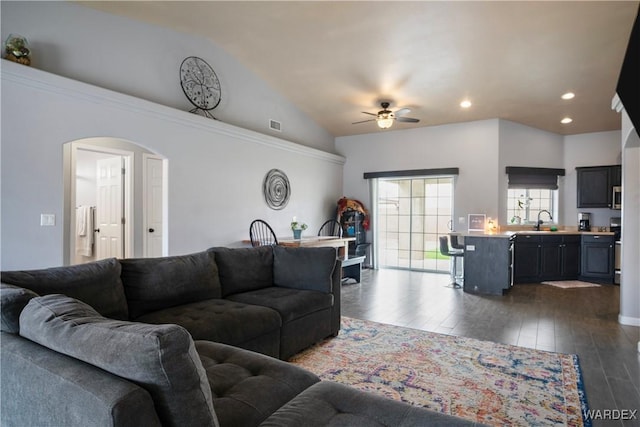 living area featuring arched walkways, dark wood finished floors, a ceiling fan, recessed lighting, and vaulted ceiling