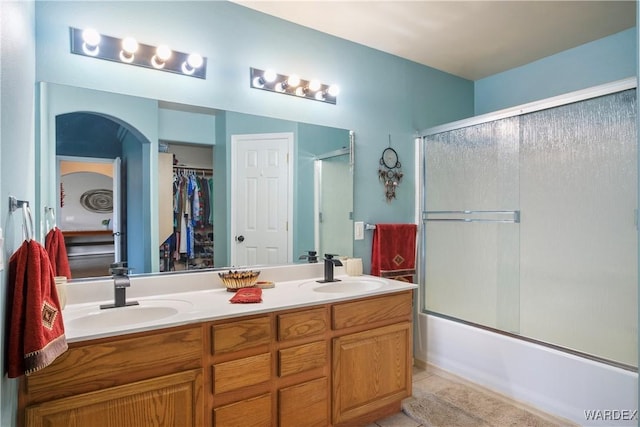 bathroom featuring a sink, bath / shower combo with glass door, tile patterned flooring, and double vanity