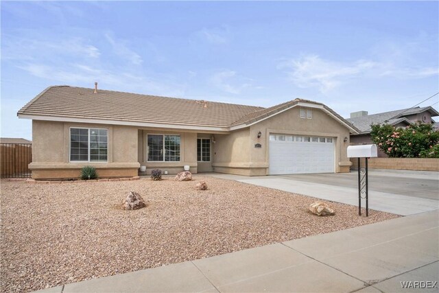 ranch-style home with a tiled roof, stucco siding, driveway, and a garage