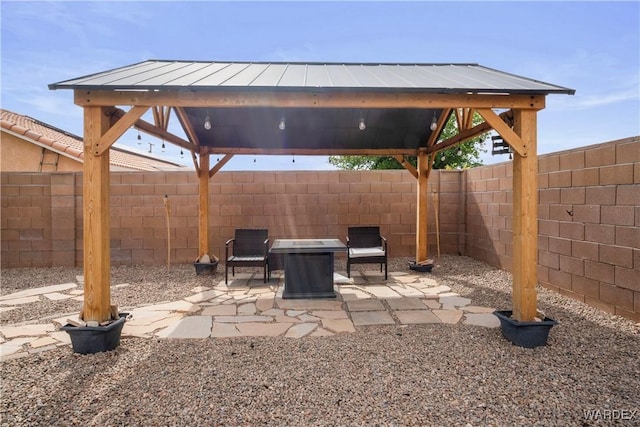 view of patio featuring a gazebo, a fire pit, and a fenced backyard