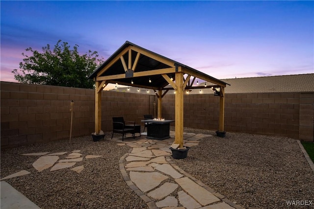 view of patio featuring a fenced backyard, a gazebo, and an outdoor fire pit