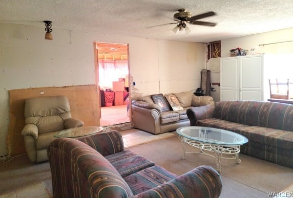 living room with ceiling fan and a textured ceiling