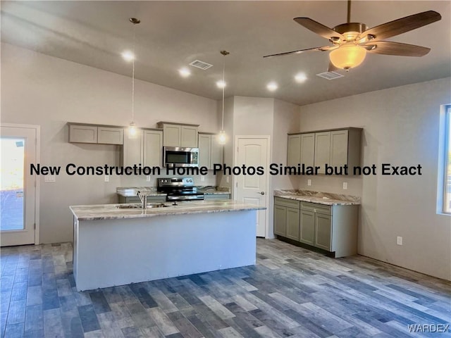 kitchen with a kitchen island with sink, stainless steel appliances, light stone counters, and visible vents