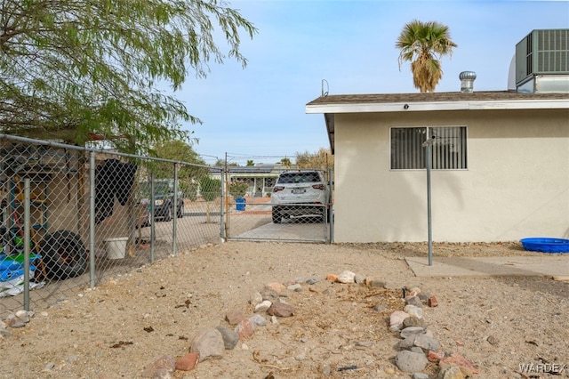 view of home's exterior featuring fence, central AC, and stucco siding