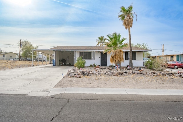 single story home featuring an attached carport, concrete driveway, and stucco siding