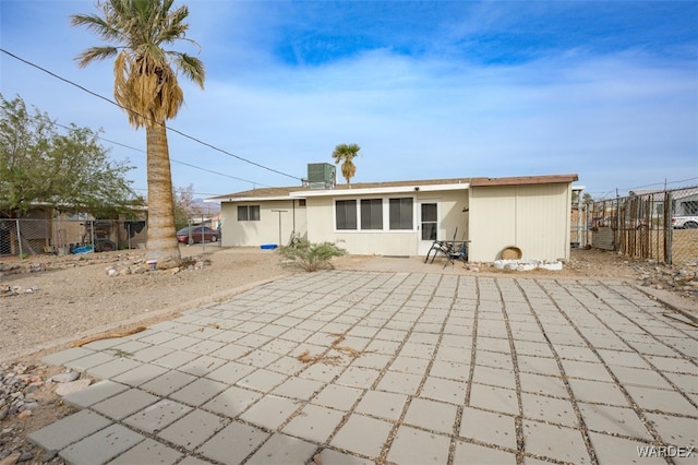 rear view of property with fence, a patio, and central AC unit