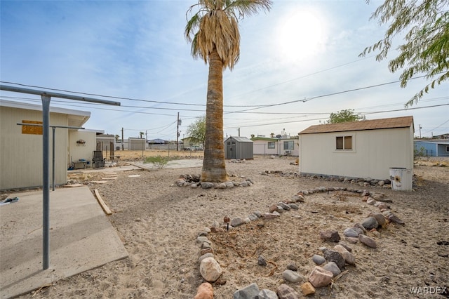 view of yard with an outbuilding, a storage unit, and a patio area