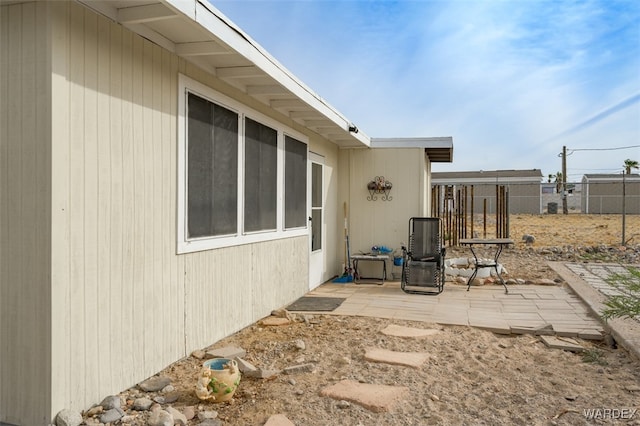 view of property exterior with a patio and fence