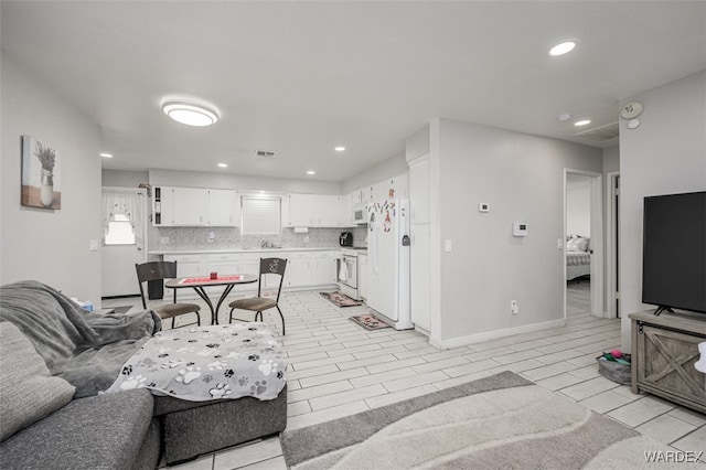 living room with baseboards, wood tiled floor, visible vents, and recessed lighting