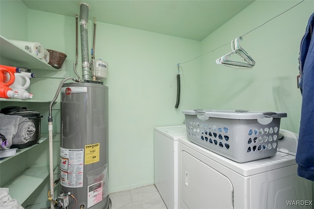 clothes washing area with water heater, laundry area, and separate washer and dryer