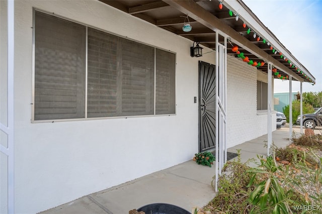 entrance to property featuring brick siding and stucco siding