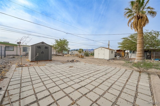 view of patio featuring a shed, fence, and an outdoor structure