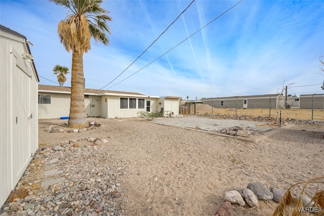 back of property featuring fence and stucco siding