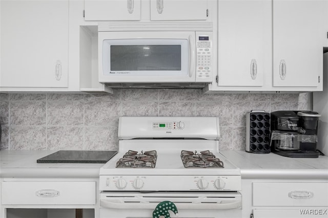 kitchen with white appliances, light countertops, backsplash, and white cabinetry