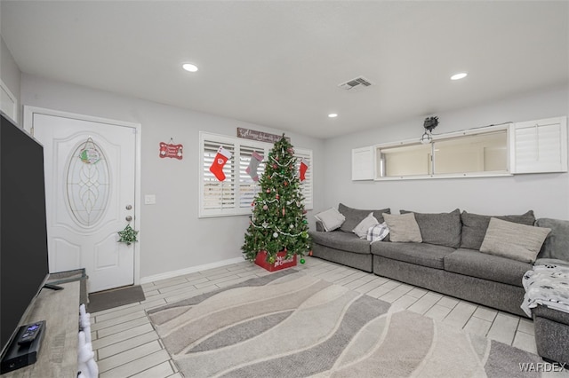 living area featuring baseboards, visible vents, light wood-style flooring, and recessed lighting