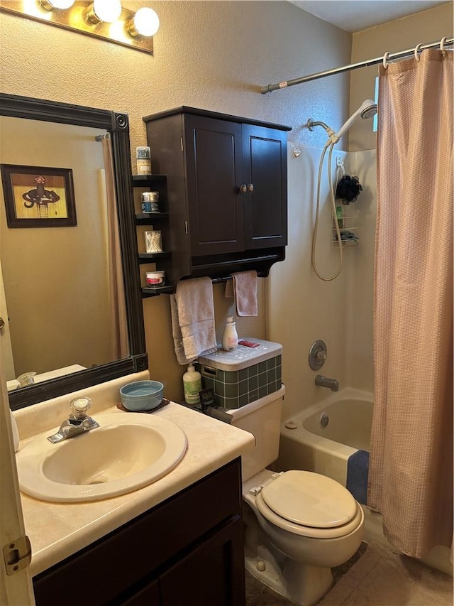 full bathroom featuring vanity, toilet, a textured wall, and shower / bath combo