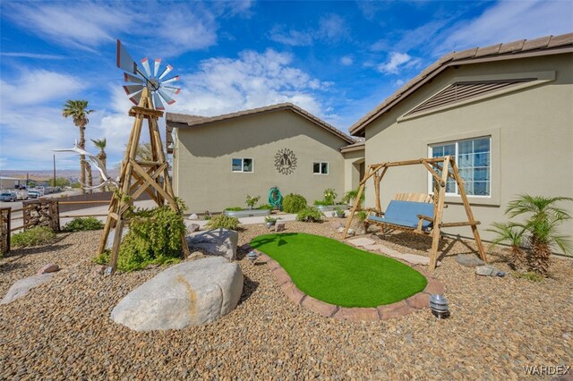 rear view of property with fence and stucco siding