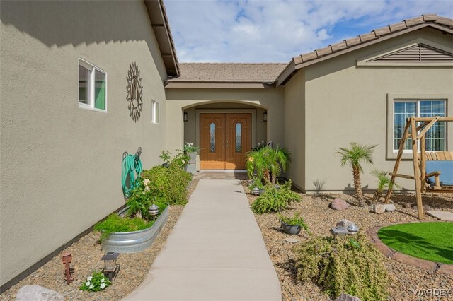 entrance to property featuring stucco siding