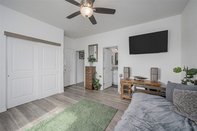 bedroom featuring light wood-style floors, ceiling fan, a closet, and ensuite bathroom