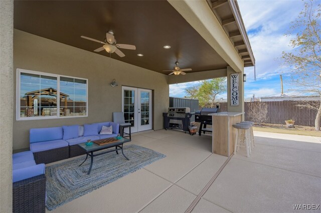 view of patio / terrace with ceiling fan, outdoor lounge area, fence, area for grilling, and outdoor dry bar