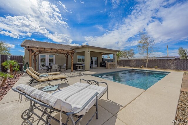 view of swimming pool featuring a fenced in pool, fence private yard, a patio area, and an outdoor bar