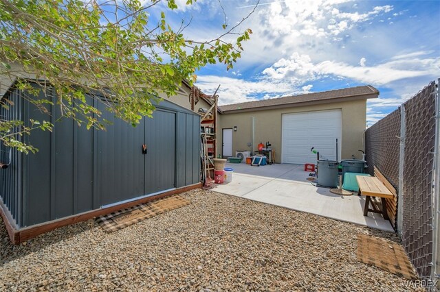 exterior space with driveway, a shed, and fence