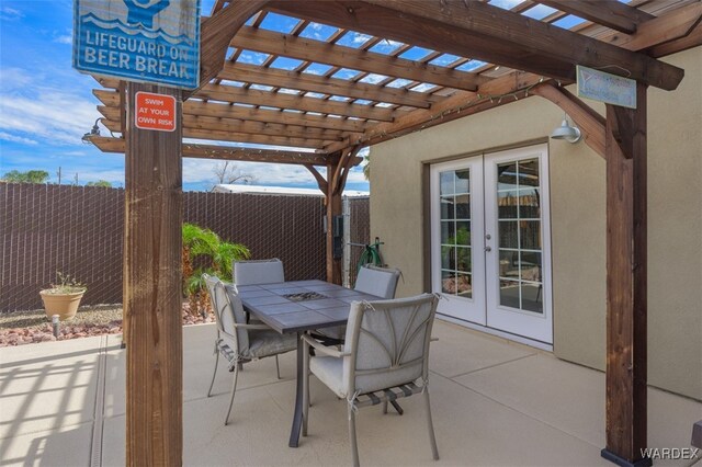 view of patio / terrace featuring french doors, outdoor dining space, fence, and a pergola