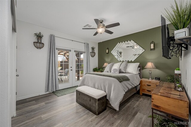 bedroom featuring access to exterior, french doors, visible vents, ceiling fan, and wood finished floors