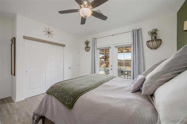 bedroom with a ceiling fan, access to exterior, french doors, a closet, and light wood-type flooring