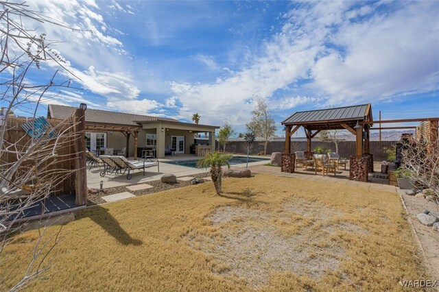 view of yard featuring a patio, fence, a gazebo, french doors, and a fenced in pool