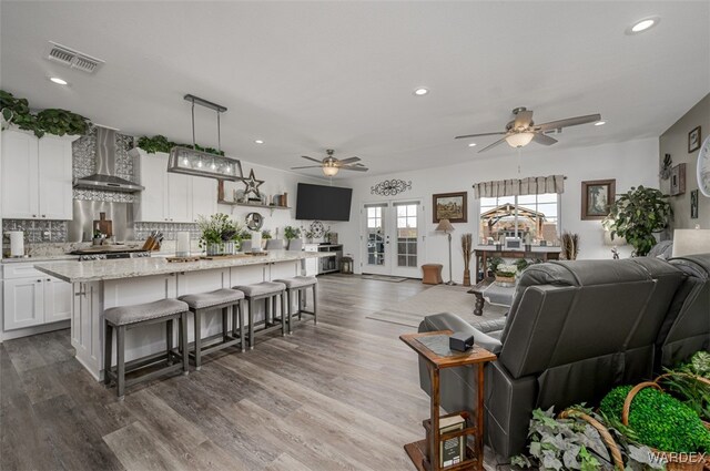 living room with recessed lighting, french doors, visible vents, and wood finished floors