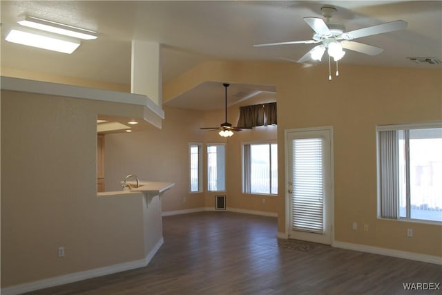 spare room featuring dark wood-style flooring, visible vents, a sink, and baseboards