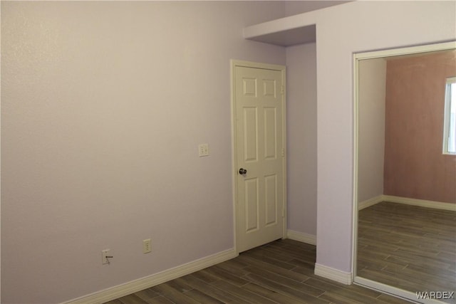 spare room featuring dark wood finished floors and baseboards