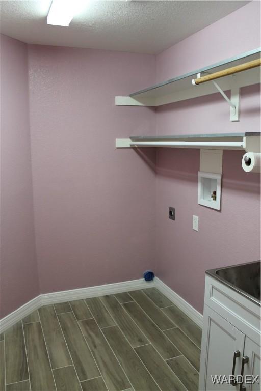 washroom with washer hookup, cabinet space, wood tiled floor, hookup for an electric dryer, and baseboards