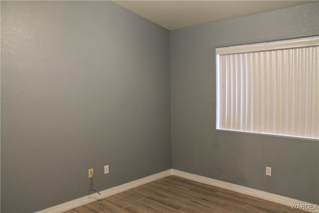 spare room with wood finish floors and baseboards