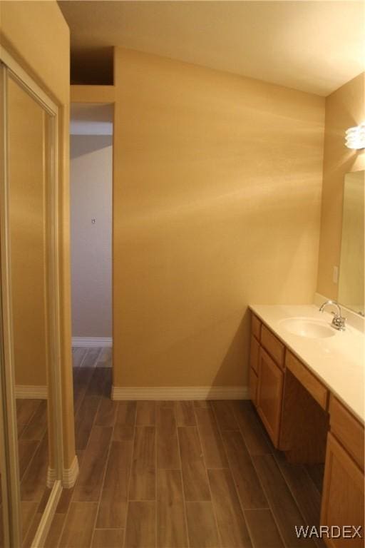 bathroom with wood tiled floor, vanity, and baseboards