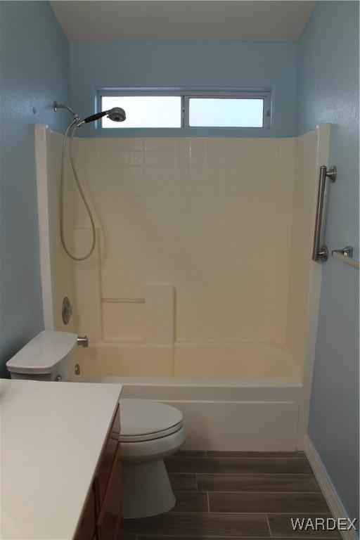 full bath with toilet, vanity, washtub / shower combination, and wood finish floors