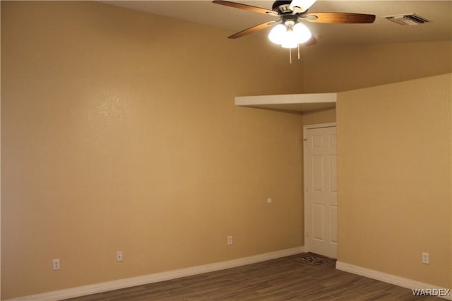 unfurnished room with a ceiling fan, visible vents, baseboards, and wood finished floors