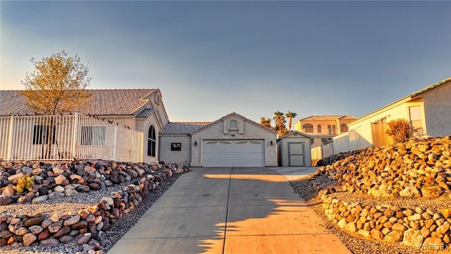 mediterranean / spanish house featuring a garage, concrete driveway, a tile roof, fence, and stucco siding