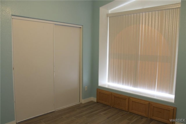 unfurnished bedroom with wood finish floors and a closet