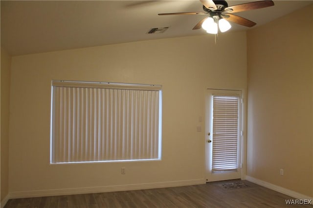 spare room with a ceiling fan, visible vents, baseboards, and wood finished floors