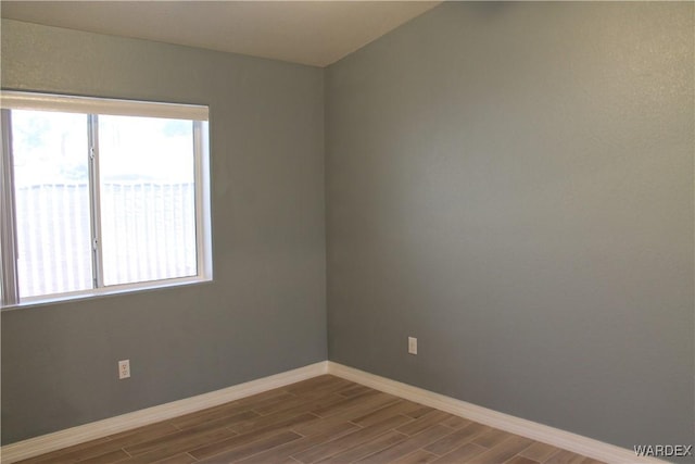 empty room with baseboards and wood tiled floor