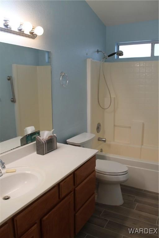 full bathroom featuring wood tiled floor, shower / bathing tub combination, vanity, and toilet