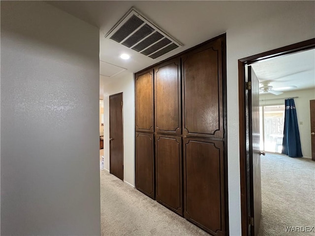 hall featuring light carpet and visible vents