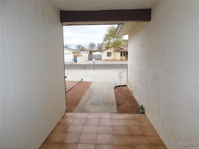 hallway with tile patterned flooring and beam ceiling