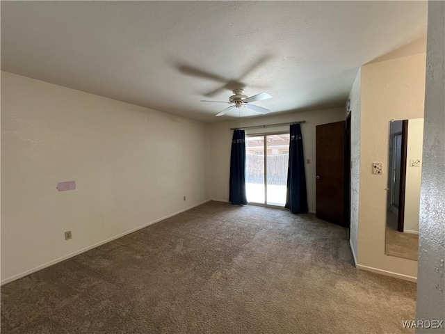 carpeted spare room featuring ceiling fan and baseboards